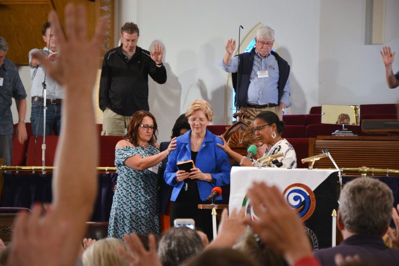 Attendees pray over Sen. Elizabeth Warren (D-Mass.) during the Festival of Homiletics at Metropolitan AME Church on May 21, 2018, in Washington. RNS photo by Jack Jenkins