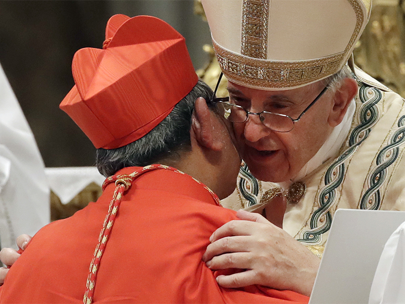 New Cardinal Louis-Marie Ling Mangkhanekhoun, from Laos, is greeted by Pope Francis after receiving the red three-cornered biretta hat during a consistory inside the St. Peter's Basilica at the Vatican, on June 28, 2017. (AP Photo/Alessandra Tarantino)