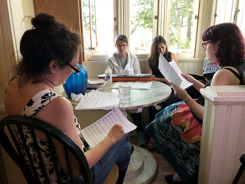 Voices of Reason choir members, from left, Christine Jones, Erin Keith, Jenny Hicks and Amanda MacLean split up into sections to master parts of a song on April 22, 2018, at Heretic House in Los Angeles. RNS photo by Heather Adams