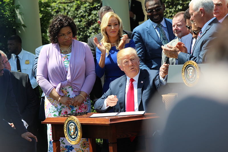 President Donald Trump passes out pens after signing the White House Faith and Opportunity Initiative executive order during a National Day of Prayer event in the Rose Garden of the White House on May 3, 2018, in Washington. RNS photo by Adelle M. Banks
