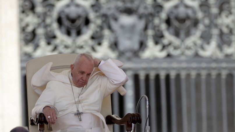 Pope Francis tries to adjust his mantle on a windy morning during his weekly general audience in St. Peter's Square, at the Vatican, on June 27, 2018. (AP Photo/Alessandra Tarantino)