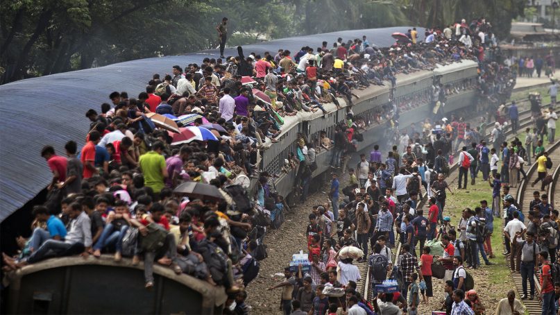 Bangladeshi Muslims maneuver their way on the roof of an overcrowded train to travel home for Eid al-Fitr celebrations, at a railway station in Dhaka, Bangladesh, on June 14, 2018. Hundreds of thousands of people working in Dhaka are leaving for their hometowns to celebrate the upcoming Eid al-Fitr holiday with their families. (AP Photo/A.M. Ahad)