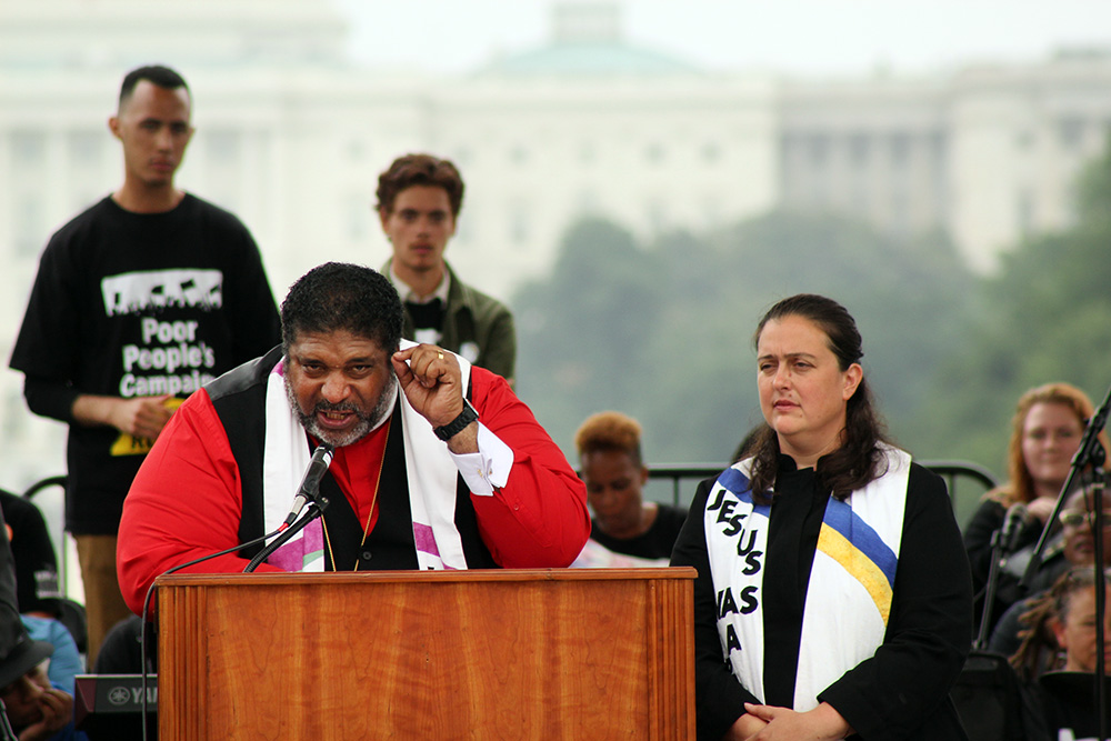 The Rev. William Barber II, co-chair of the Poor People’s Campaign, speaks on the National Mall, June 23, 2018. Fellow co-chair the Rev. Liz Theoharis stands on the right. RNS photo by Adelle M. Banks
