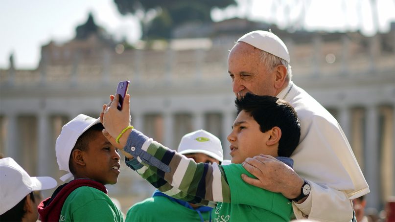A boy takes a selfie with Pope Francis as he arrives in St. Peter's Square for his general weekly audience, at the Vatican on March 14, 2018.  March 13 was the 5-year anniversary of Pope Francis’ election as Bishop of Rome. (AP Photo/Andrew Medichini)