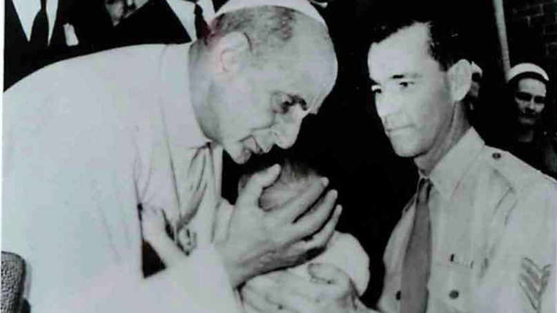 Pope Paul VI kisses a baby held by his soldier father at the Royal Alexandra Hospital for Children in Sydney, Australia, in 1970. RNS file photo