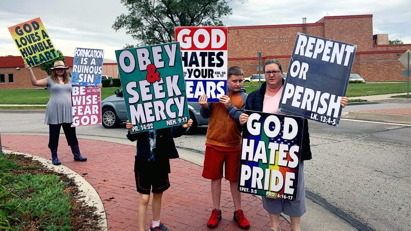 Westboro Baptist Church members demonstrate outside of Olathe North High School on May 20, 2018, near Kansas City. Nearly all WBC signs now contain biblical references. Photo courtesy of WBC