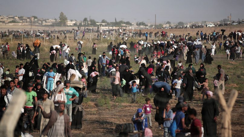 Thousands of Syrian refugees walk in order to cross into Turkey on June 14, 2015, in Akcakale, Sanliurfa province, in southeastern Turkey. (AP Photo/Lefteris Pitarakis)