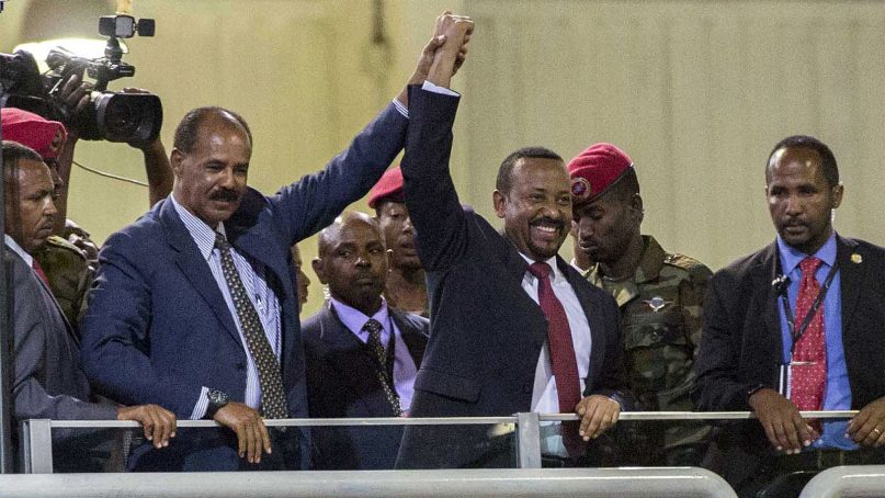 Eritrean President Isaias Afwerki, left, and Ethiopia's Prime Minister Abiy Ahmed, center, hold hands as they wave at the crowds in Addis Ababa, Ethiopia, on July 15, 2018. Official rivals just weeks ago, the leaders of Ethiopia and Eritrea have embraced warmly to the roar of a crowd of thousands at a concert celebrating the end of a long state of war. (AP Photo/Mulugeta Ayene)