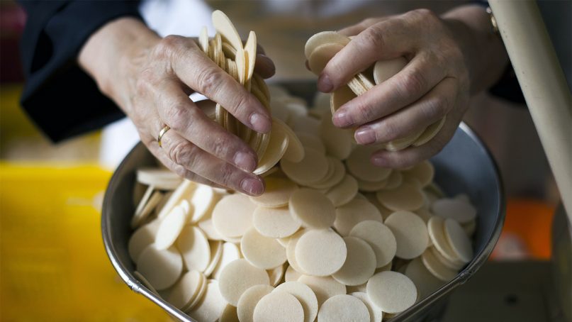 Sister Placida scales hosts at the Benedictine Abbey of St. Gertrud's host bakery in Alexanderdorf, Germany, about 30 miles south of Berlin, on July 28, 2011. (AP Photo/Markus Schreiber)
