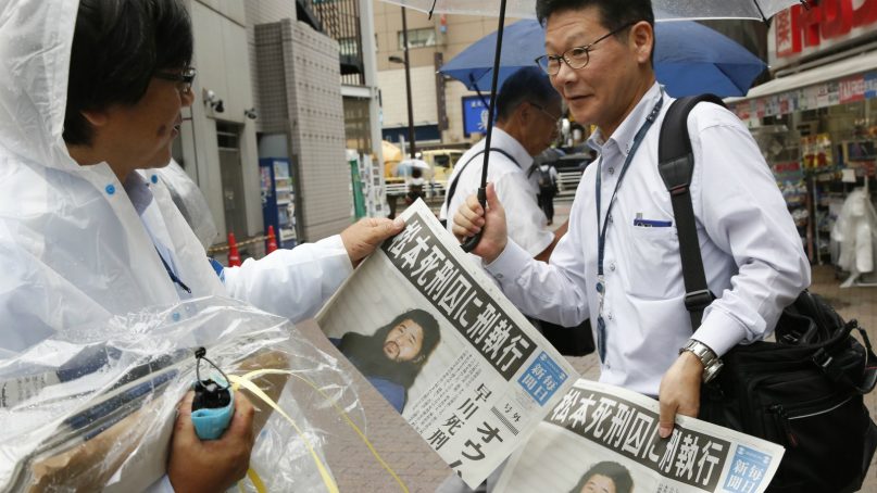 A staff member of Japanese newspaper Mainichi Shimbun distributes the extra edition reporting that doomsday cult leader Shoko Asahara was executed, at a station in Tokyo on July 6, 2018. Asahara and six followers were executed Friday for their roles in a deadly 1995 gas attack on the Tokyo subways and other crimes, Japan's Justice Ministry said. (AP Photo/Shuji Kajiyama)