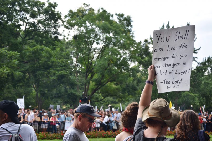 A demonstrator holds a religious sign at a massive counter-protest meant to oppose the 