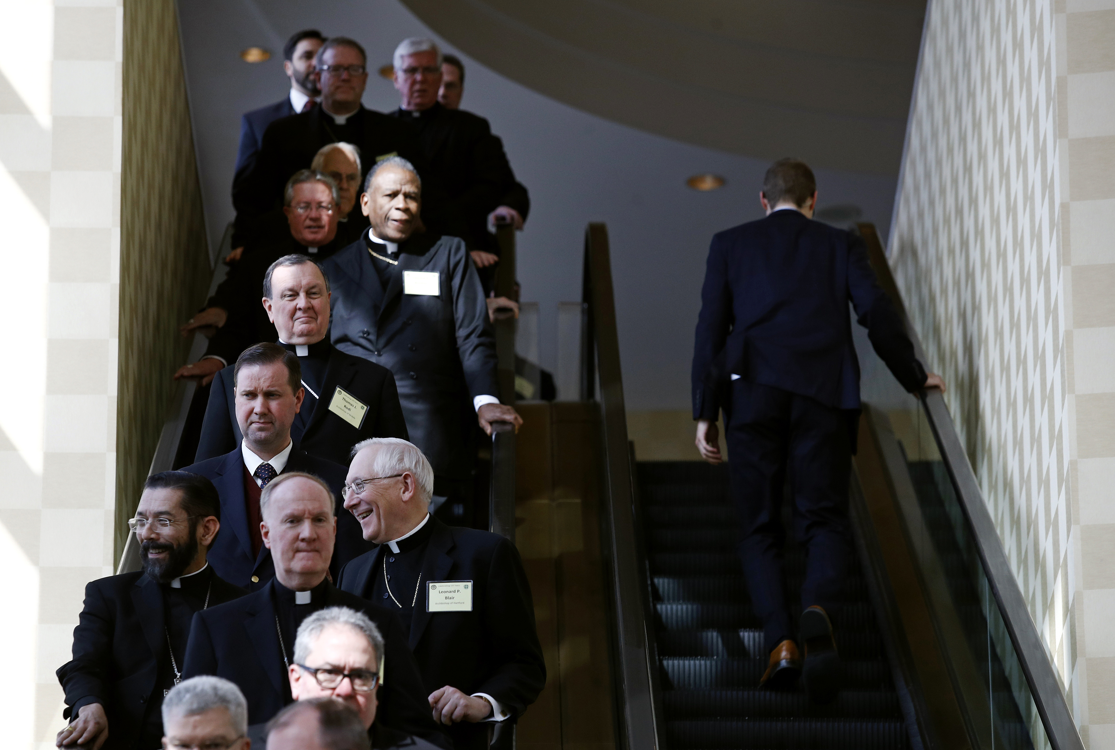 Members of the the United States Conference of Catholic Bishops ride an escalator during a break in sessions at the USCCB's annual fall meeting in Baltimore, on Nov. 13, 2017. (AP Photo/Patrick Semansky)