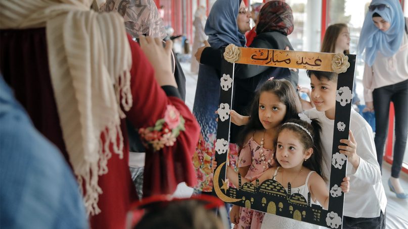 Children pose with a frame decorated with holiday wishes after Eid al-Adha prayers in Bucharest, Romania, on Aug. 21, 2018. Muslims worldwide are celebrating Eid al-Adha, or the Feast of the Sacrifice, which commemorates the biblical story of Abraham and his readiness to sacrifice his son as an act of obedience to God, by sacrificial killing of sheep, goats, cows or camels. (AP Photo/Vadim Ghirda)
