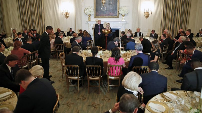 President Trump bows his head as pastor Paula White leads the room in prayer during a dinner for evangelical leaders in the State Dining Room of the White House on Aug. 27, 2018, in Washington. (AP Photo/Alex Brandon)