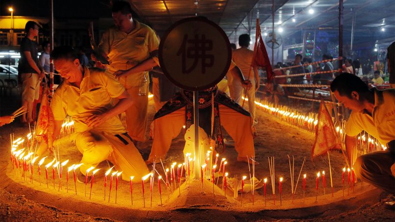 Ethnic Chinese burns joss sticks and candles during the Chinese Hungry Ghost Festival in Puchong, Malaysia, on Aug. 16, 2018. The Hungry Ghost Festival is celebrated during the seventh month of the Chinese lunar calendar, when prayers are offered to the dead and offerings of food and paper-mache models of earthly items such as televisions, refrigerators and sport cars are burned to appease the wandering spirits. It is believed that the gates of hell are opened during the month and the dead ancestors return to visit their relatives.(AP Photo/Yam G-Jun)