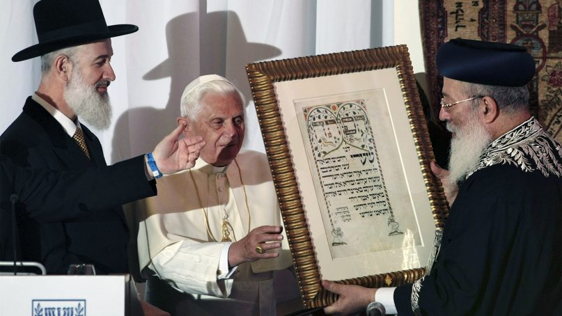 Then-Pope Benedict XVI receives a gift from Israeli chief Rabbis Shlomo Amar, right, and Yona Metzger, left, at the center for the Jewish Heritage in Jerusalem, on May 12, 2009. The pope told Israel's two chief rabbis that the Catholic Church is 