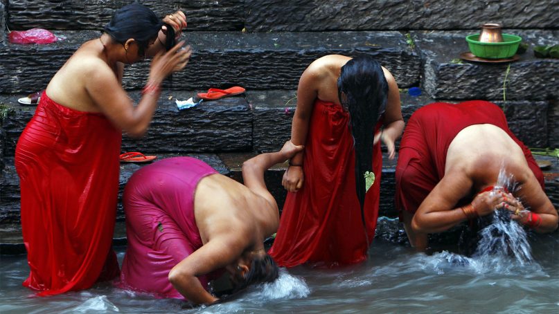 Nepalese Hindu women bathe in the Bagmati River on Rishi Panchami, a day when rituals are performed to wash away sins committed during menstruation, a period considered impure, in Kathmandu, Nepal, on Sept. 10, 2013. Nepal's Parliament has passed a bill that went into effect in August 2018 and aims to make women safer by stopping the custom of exiling women who are menstruating. (AP Photo/Niranjan Shrestha)