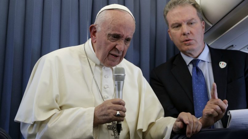 Pope Francis, flanked by Vatican spokesperson Greg Burke, listens to a journalist's question Aug. 26, 2018, during a news conference aboard the flight to Rome at the end of his two-day visit to Ireland. (AP Photo/Gregorio Borgia, Pool)