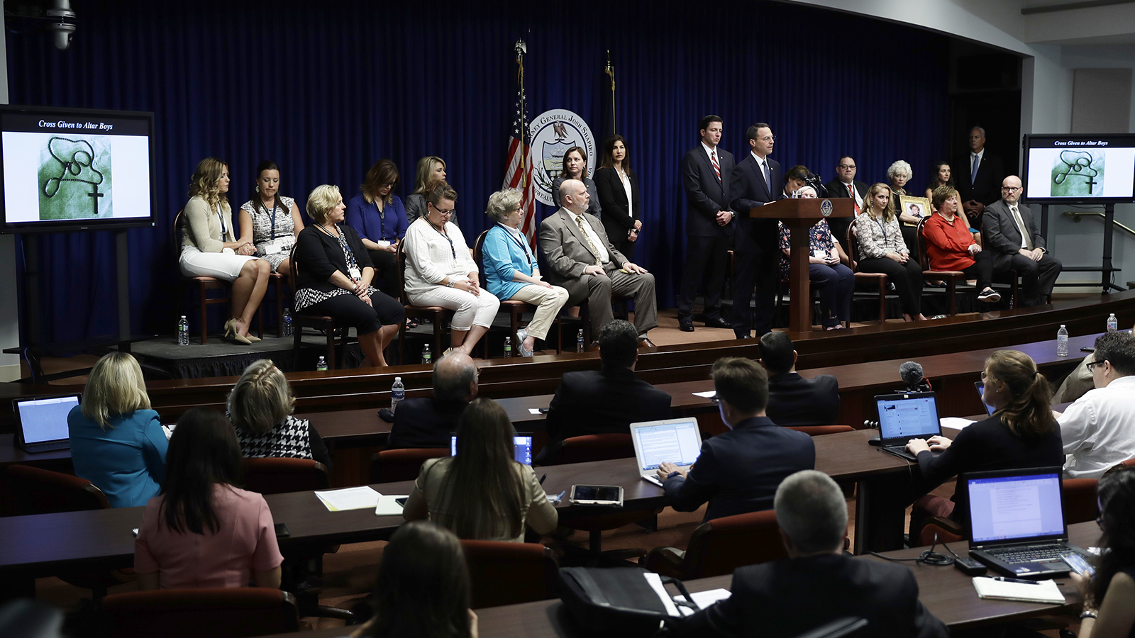Pennsylvania Attorney General Josh Shapiro speaks during a news conference at the state Capitol in Harrisburg, Pa., on Aug. 14, 2018. A Pennsylvania grand jury says its investigation of clergy sexual abuse identified more than 1,000 child victims. The grand jury report says that number comes from records in six Roman Catholic dioceses. The people seated were some of those affected by the clergy abuse. (AP Photo/Matt Rourke)