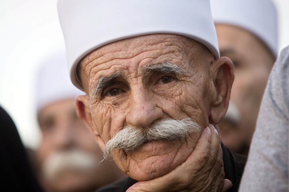 An Israeli man from the Druze community participates in a rally against Israel's Jewish Nation bill in Tel Aviv, on Aug. 4, 2018. Thousands of members of Israel's Druze minority and their Jewish supporters packed a central Tel Aviv square Saturday night to rally against a contentious new law that critics say sidelines Israel's non-Jewish citizens. (AP Photo/Sebastian Scheiner)