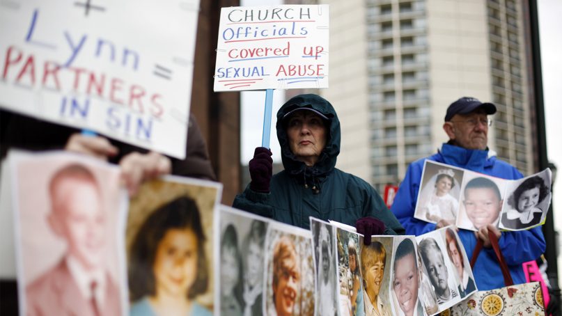 Catherine Coleman Murphy, center, and Jack Wintermyer, right, protest along with others outside Cathedral Basilica of Sts. Peter and Paul before an Ash Wednesday Mass in Philadelphia on March 9, 2011. (AP Photo/Matt Rourke)