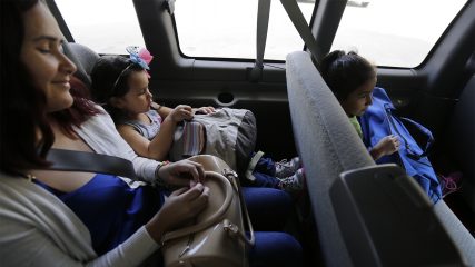 Brazilian immigrants seeking asylum Natalia Oliveira da Silva, left, sits with her daughter, Sara, 5, center, as they go from a hotel to a Catholic Charities facility on July 23, 2018, in San Antonio. Since their separation in late May, the girl had been at a shelter for immigrant minors in Chicago, while Oliveira was taken to various facilities across Texas. (AP Photo/Eric Gay)