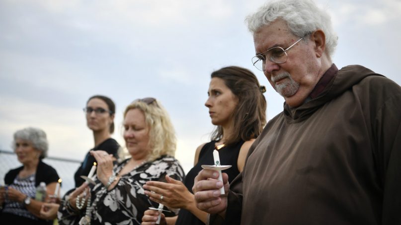 John Boylan of Christ the Prophet Church in Spring Hill, Tenn, holds a candle as protesters gather outside of the Riverbend Maximum Security Institution against the execution of inmate Billy Ray Irick in Nashville, Tenn., Thursday, Aug. 9, 2018. Irick, 59, is scheduled to receive a three-drug injection Thursday evening at the maximum-security prison. He was convicted in 1986 in the death of Paula Dyer, a Knoxville girl he was babysitting. (Andrew Nelles/The Tennessean via AP)