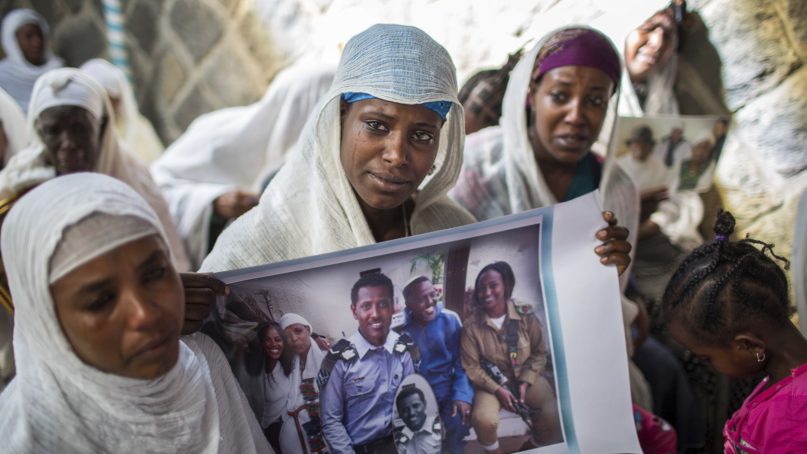 Members of Ethiopia's Jewish community hold pictures of their relatives in Israel, during a solidarity event at the synagogue in Addis Ababa, Ethiopia, on  Feb. 28, 2018. Hundreds of Ethiopian Jews gathered at the synagogue to express concern that Israel's proposed budget removes the funding to help them immigrate to reunite with relatives in that country, as representatives said they will stage a mass hunger strike if Israel eliminates the funding. (AP Photo/Mulugeta Ayene)