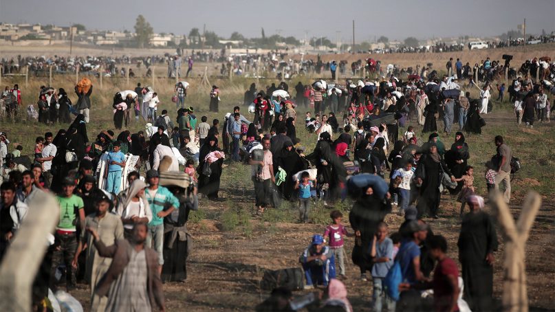 Thousands of Syrian refugees walk in order to cross into Turkey on June 14, 2015, in Akcakale, Sanliurfa province, in southeastern Turkey. (AP Photo/Lefteris Pitarakis)