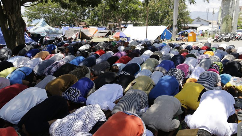 Evacuees pray Oct. 5, 2018, near tents outside a mosque damaged by the massive earthquake and tsunami in Palu, Central Sulawesi, Indonesia. Hundreds of Muslim survivors in the Indonesian city of Palu gathered at shattered mosques for Friday prayers, seeking strength to rebuild their lives a week after a powerful earthquake and tsunami killed more than 1,500 people. (AP Photo/Aaron Favila)