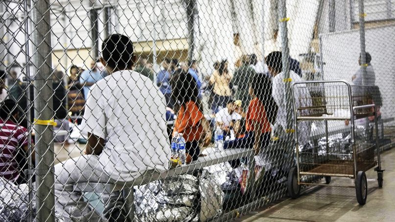 In this June 17, 2018, photo provided by U.S. Customs and Border Protection, people who were taken into custody related to cases of illegal entry into the United States sit in one of the cages at a facility in McAllen, Texas. (U.S. Customs and Border Protection's Rio Grande Valley Sector via AP)