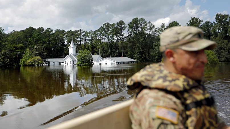 A church sits flooded as U.S. Army Spc. Daniel Ochoa rides in the back of a high-water vehicle while searching for residents to evacuate in the aftermath of Hurricane Florence in Spring Lake, N.C., on Sept. 17, 2018. (AP Photo/David Goldman)