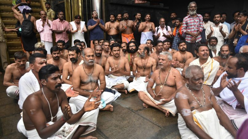 Hindu priests and temple staff sit on a protest against a ruling from India's top court to let women of menstruating age entering Sabarimala temple, one of the world's largest Hindu pilgrimage sites, in the southern Indian state of Kerala, Friday, Oct. 19, 2018. The country's Supreme Court had on Sept. 28, lifted the temple's ban on women of menstruating age, holding that equality is supreme irrespective of age and gender. Two young women, a journalist and an activist, were forced to turn back after they had reached the temple precincts under a heavy police escort. (AP Photo)