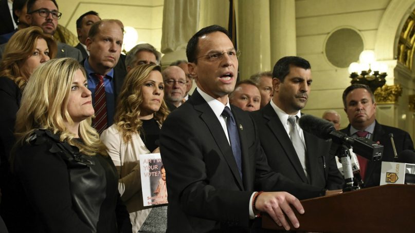 Attorney General Josh Shapiro of Pennsylvania speaks at a news conference in the state Capitol after legislation to respond to a landmark grand jury report accusing hundreds of Roman Catholic priests of sexually abusing children over decades stalled in the Legislature, on Oct. 17, 2018, in Harrisburg, Pa. Shapiro is flanked by lawmakers and victims of child sexual abuse. (AP Photo/Marc Levy)