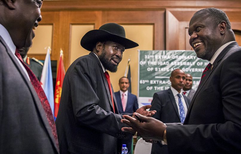 South Sudan President Salva Kiir, center, and opposition leader Riek Machar, right, shake hands during peace talks at a hotel in Addis Ababa, Ethiopia, on June 21, 2018. (AP Photo/Mulugeta Ayene)
