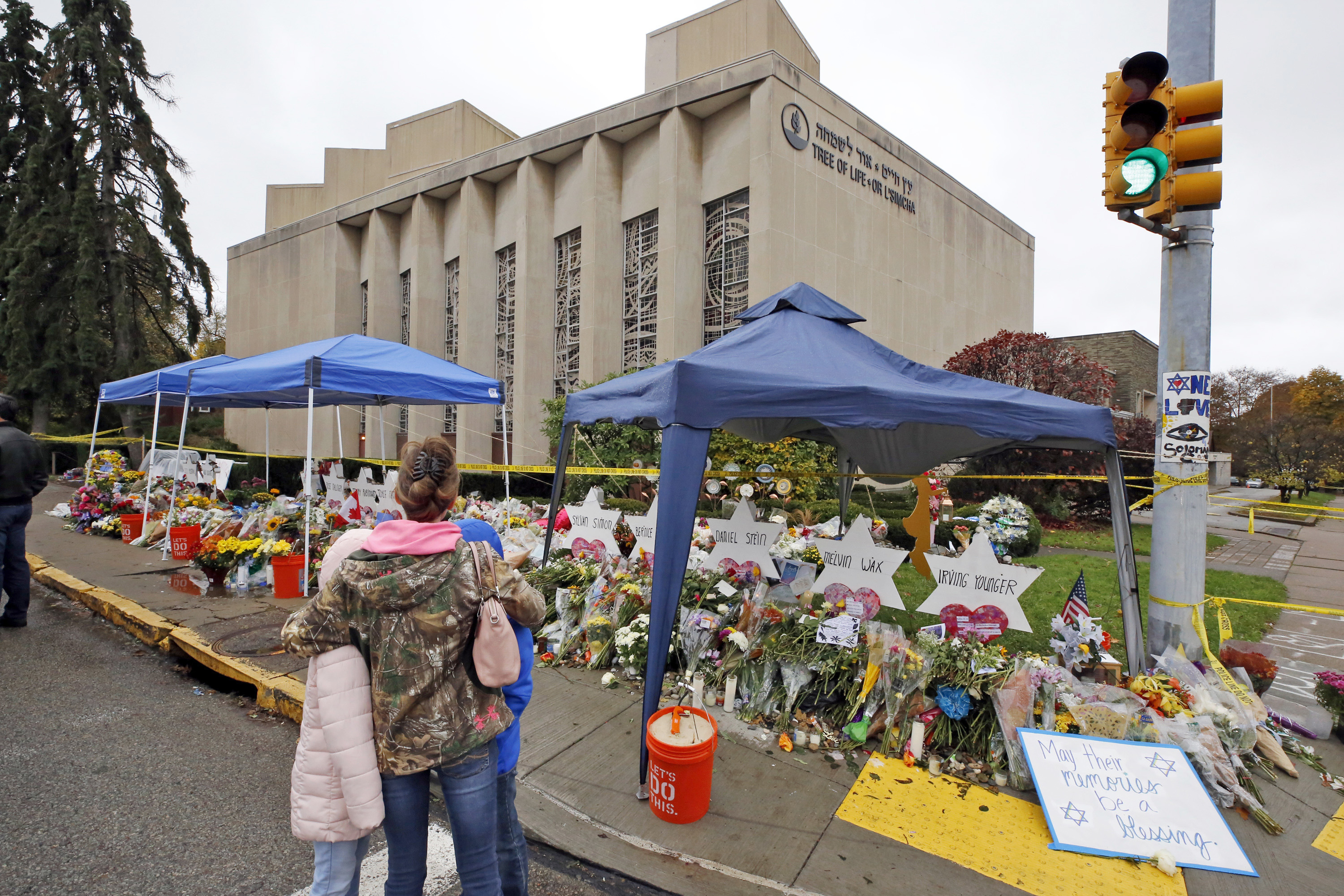 A woman and her children pause Nov. 3, 2018, to take in a makeshift memorial outside the Tree of Life synagogue honoring the 11 people killed Oct. 27, 2018, while worshipping in the Squirrel Hill neighborhood of Pittsburgh. (AP Photo/Gene J. Puskar)