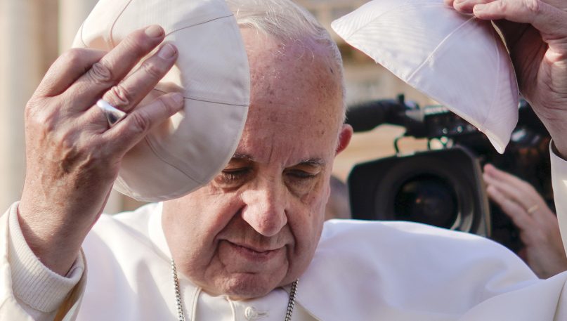 Pope Francis tries a cap he was offered as he leaves at the end of his weekly general audience in St. Peter's Square at the Vatican on Nov. 21, 2018. (AP Photo/Andrew Medichini)