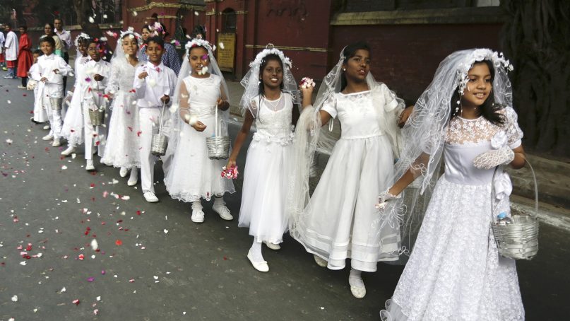 Flower girls throw petals on a road during the annual Corpus Christi procession organized on the Feast of Christ the King in Kolkata, India, on Nov. 20, 2016. About 10,000 Catholics joined the annual rally organized by the Catholic Association of Bengal. (AP Photo/Bikas Das)