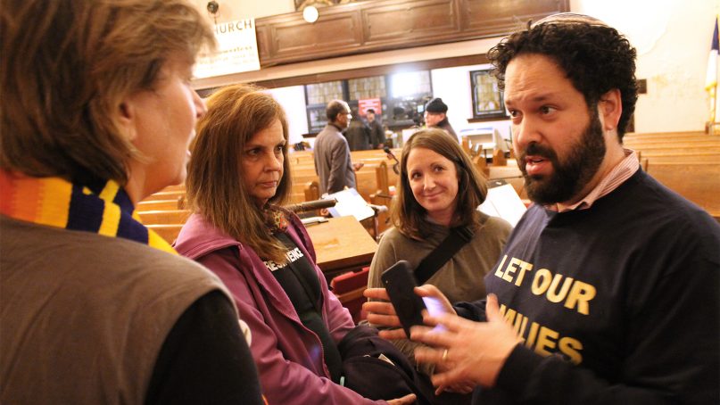 Rabbi Josh Whinston, right, of Temple Beth Emeth in Ann Arbor, Mich., speaks with a group of activists, including Erin Maloney, second from left, during a stop of the 