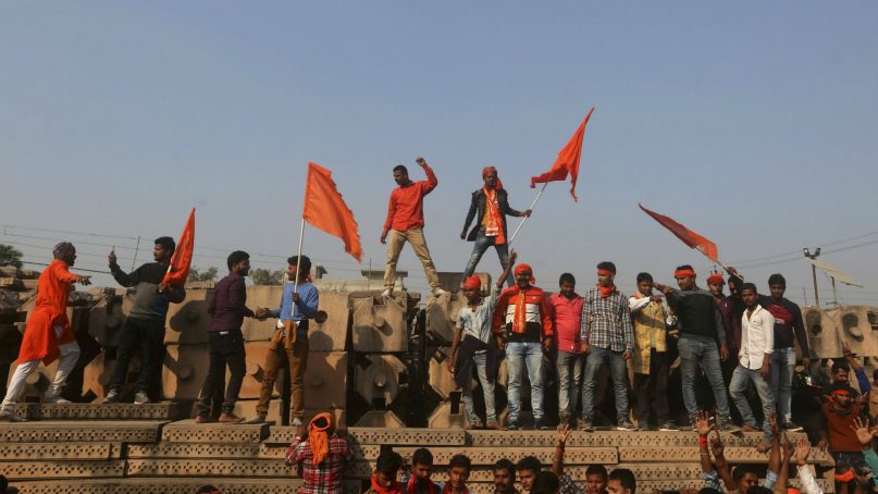 Supporters of Vishwa Hindu Parishad or World Hindu Council stand on blocks prepared for making a new temple as they gather Nov. 25, 2018, for a rally to demand the construction of a Ram temple in Ayodhya, India. Tens of thousands of Hindus gathered in the northern Indian city renewing calls to build a Hindu temple on a site where a mosque was attacked and demolished in 1992, sparking deadly Hindu-Muslim violence. (AP Photo)