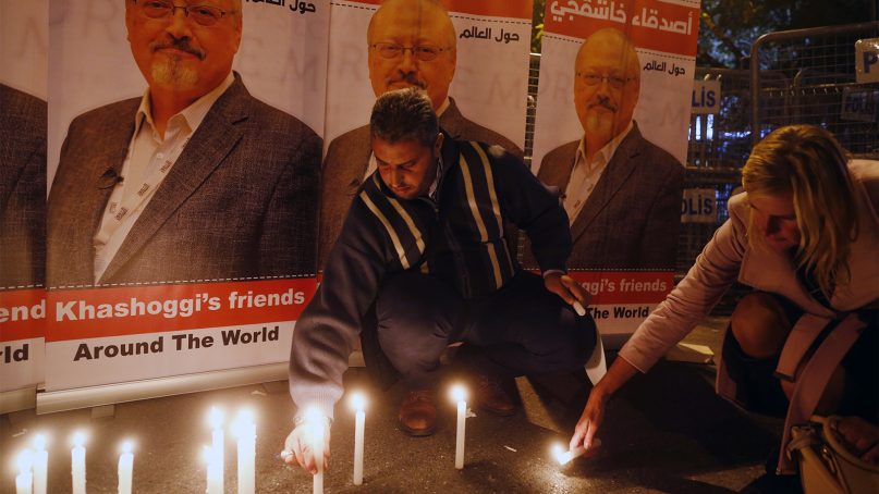 Individuals protesting the killing of Saudi journalist Jamal Khashoggi hold a candlelight vigil outside Saudi Arabia's consulate in Istanbul, on Oct. 25, 2018. (AP Photo/Lefteris Pitarakis)