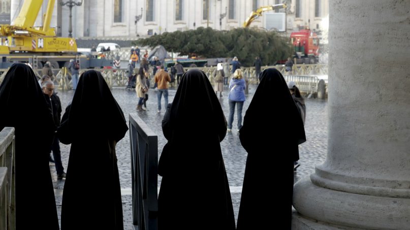 Nuns look as a crane raises a 68-foot-tall Christmas tree at the Vatican on Nov. 22, 2018. The tree, from the northern Italian Consiglio forest, was donated by the Friuli Venezia Giulia region. (AP Photo/Andrew Medichini)