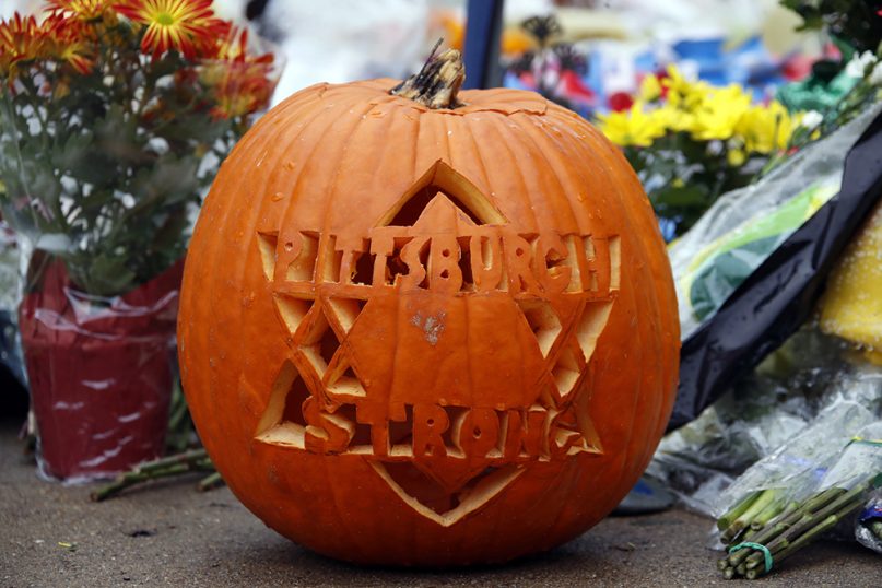 A pumpkin carved with the message ‘Pittsburgh Strong’ sits among flowers outside the Tree of Life synagogue, on Nov. 1, 2018, as part of a makeshift memorial dedicated to those killed while worshipping at the synagogue on Oct. 27 in the Squirrel Hill neighborhood of Pittsburgh. (AP Photo/Gene J. Puskar)