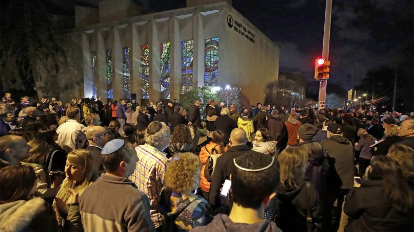 Rabbi Jeffrey Myers leads a gathering in Hanukkah songs after lighting a menorah outside the Tree of Life synagogue on the first night of Hanukkah, Dec. 2, 2018, in the Squirrel Hill neighborhood of Pittsburgh. A gunman shot and killed 11 people while they worshipped on Oct. 27, 2018, at the temple. (AP Photo/Gene J. Puskar)