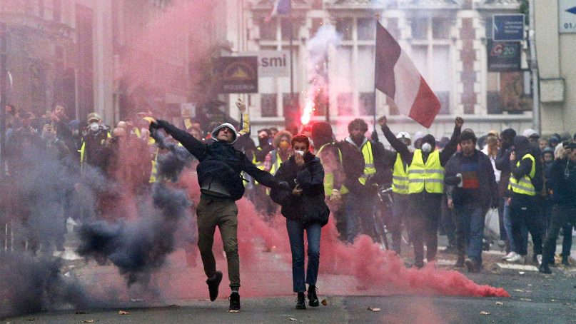 Demonstrators clash with police in Paris, France, on Dec. 8, 2018. Crowds of protesters angry at President Emmanuel Macron and France's high taxes tried to converge on the presidential palace Saturday, some scuffling with police firing tear gas, amid exceptional security measures aimed at preventing a repeat of last week's rioting. (AP Photo/Thibault Camus)