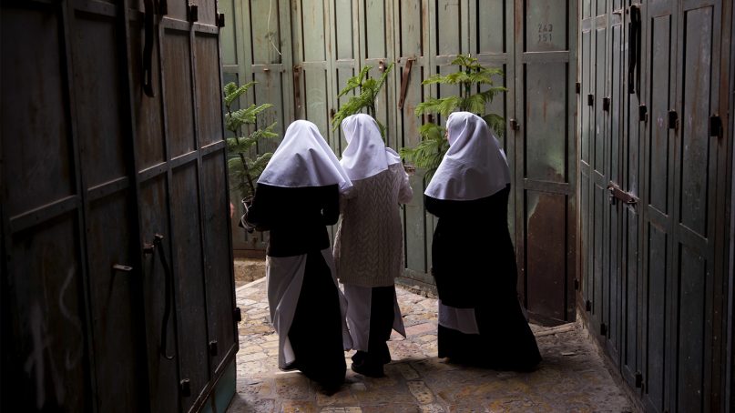 Christian nuns carry Christmas trees in Jerusalem’s Old City ahead of the holiday in December 2017. (AP Photo/Oded Balilty)