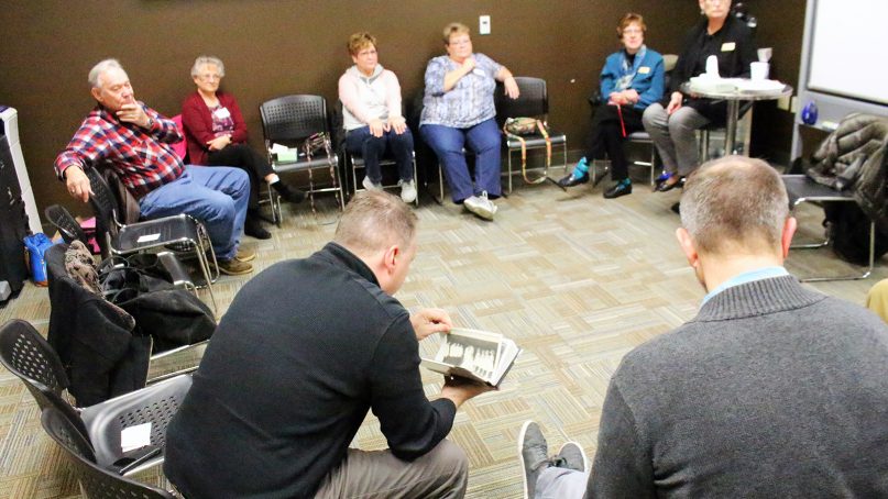 People gathered for an Alzheimer’s caregiver support group pass around a photo album one man shared of his wedding to his wife, who now is in a late stage of the disease. The group met on a campus of Southeast Christian Church in Louisville, Ky., on Nov. 28, 2018. RNS photo by Adelle M. Banks