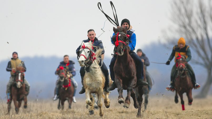 Villagers compete in an Epiphany celebration horse race in Pietrosani, Romania, on Jan. 6, 2019. The horse race tradition started in the area more then one hundred years ago, according to locals, and it was banned during the years of Communist rule, due to its association with a religious holiday. (AP Photo/Vadim Ghirda)