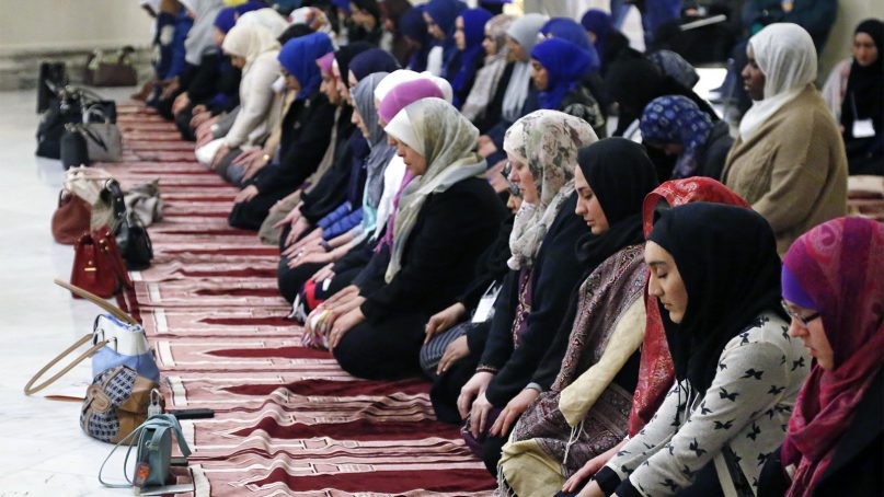 Women pray during an inter-faith prayer service during Muslim Day at the state Captiol in Oklahoma City, on Feb. 27, 2015. Prayer carpets in mosques have a row of arches. (AP Photo/Sue Ogrocki)