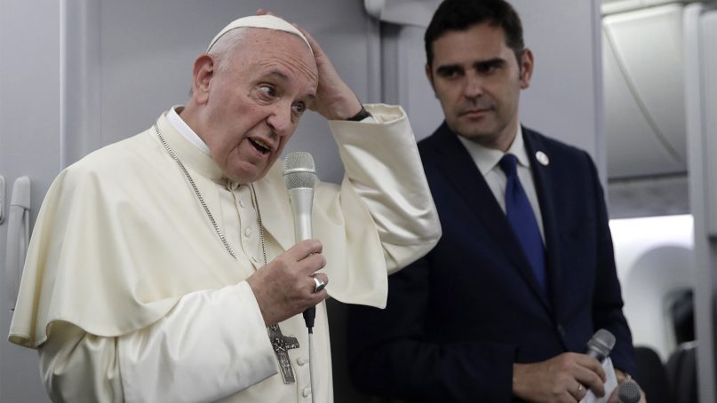 Pope Francis, flanked by Vatican spokesman Alessandro Gisotti, answers reporters' questions aboard the plane after taking off from Panama City on Jan. 27, 2019. (AP Photo/Alessandra Tarantino, Pool)